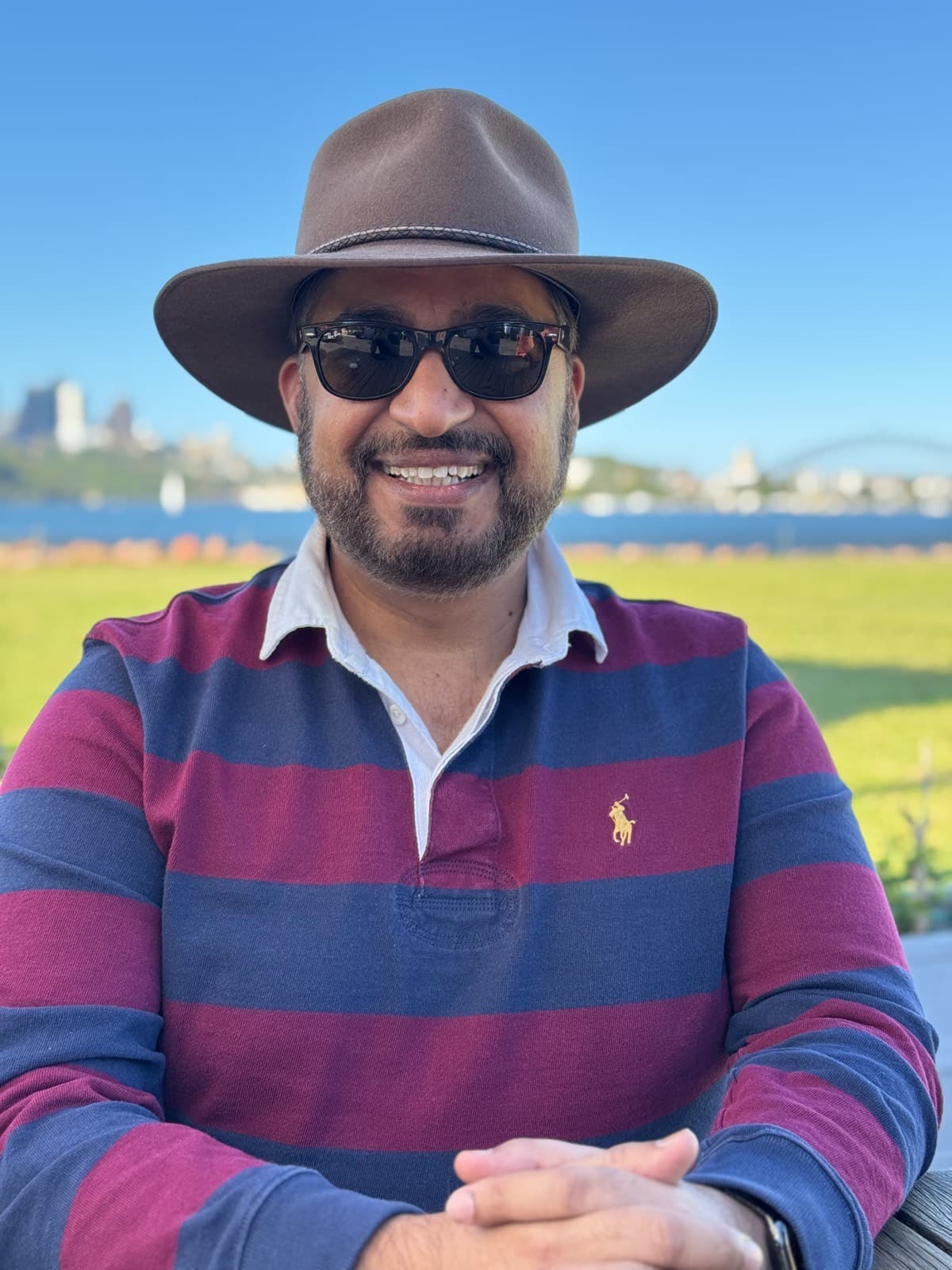 Khalid, founder of WOMBATS Shield, in an Akubra hat on Sydney Harbour on a clear day.